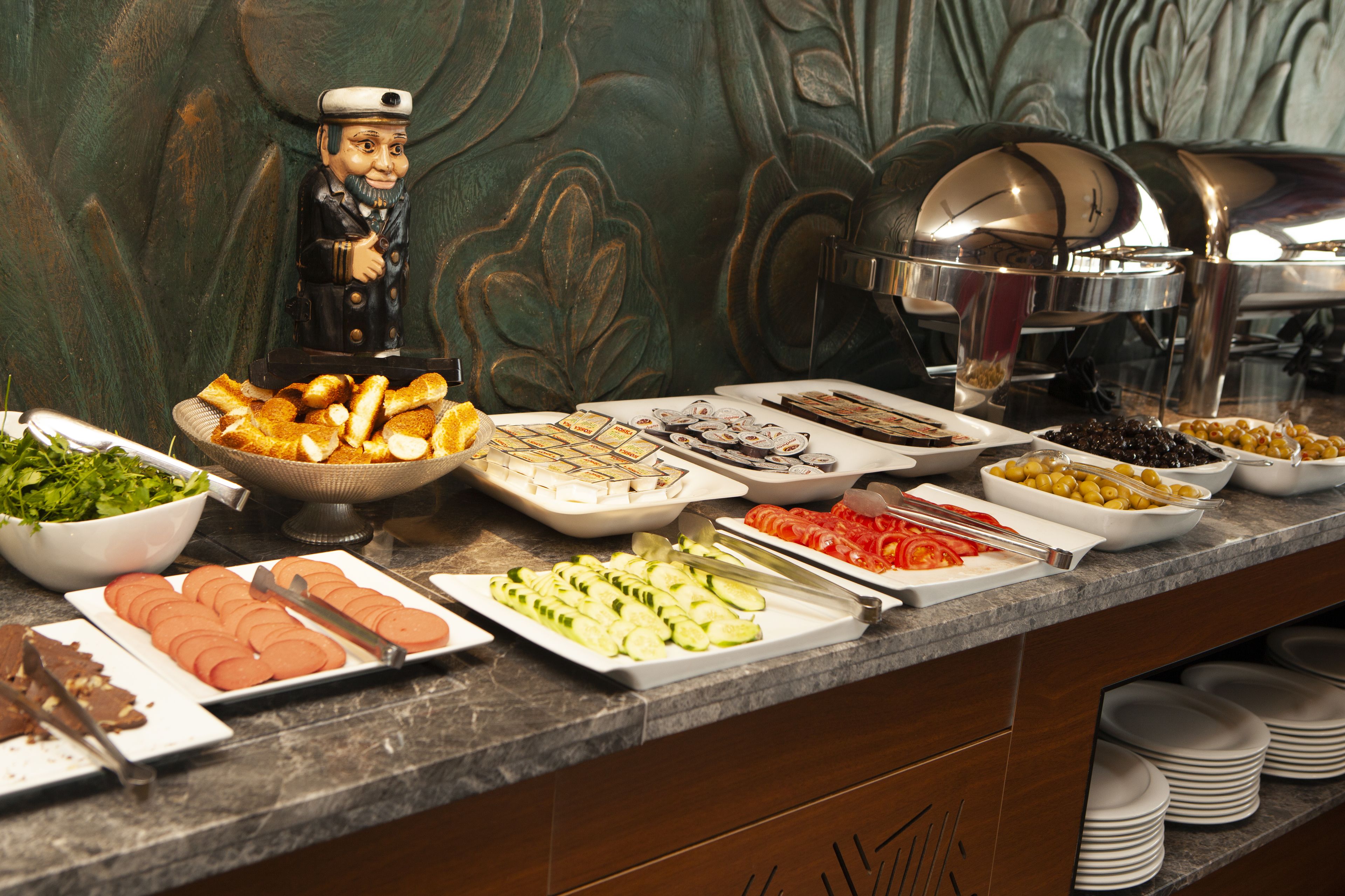 A buffet with various food items including bread, salads, and sliced meats.