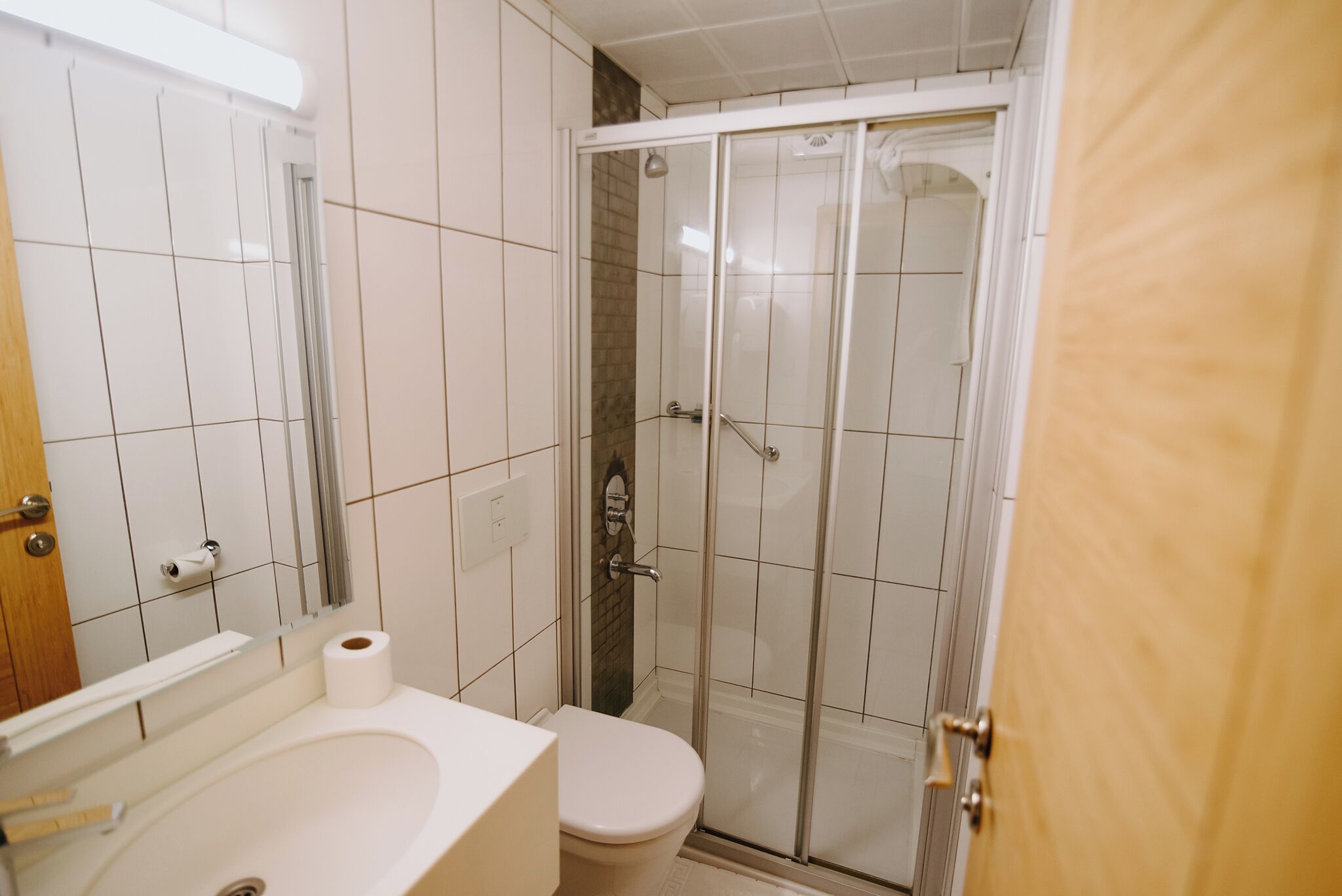 A bathroom with a toilet, sink, and shower.