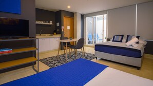 Een moderne slaapkamer met een bed, een bureau en een televisie.