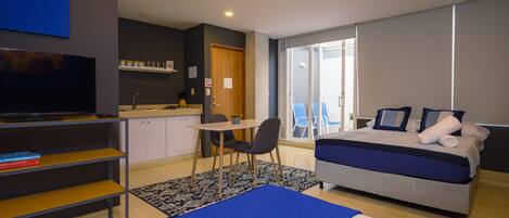 Un dormitorio moderno con cama, escritorio y televisor.