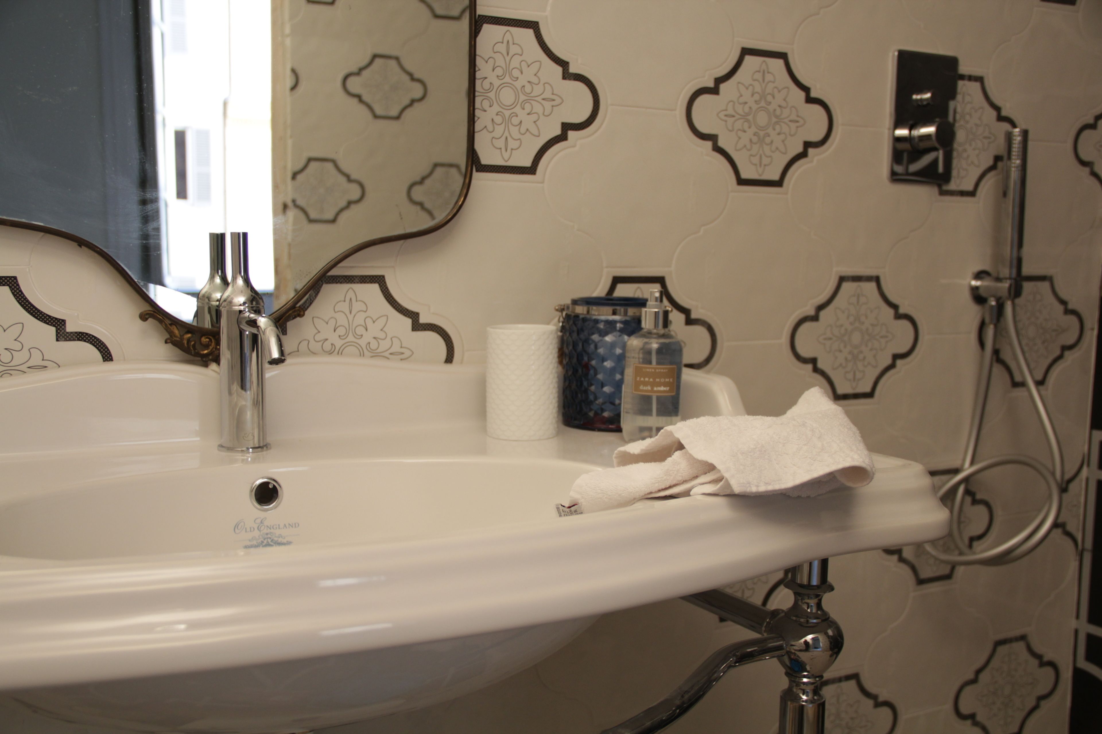 A bathroom sink with a mirror, a towel, and toiletries.