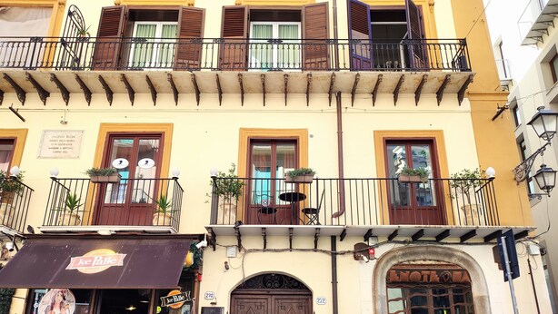 A building with a ground-floor bar named "kePalle," featuring outdoor seating and a signboard. - Dimora Bellini residenza d' epoca (Palermo)