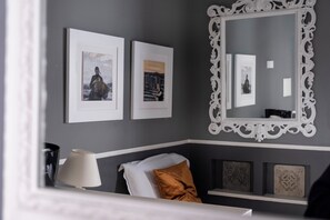 A room with a bed, a nightstand, a lamp, framed pictures on the wall, and a decorative mirror. - Dimora Bellini residenza d' epoca (Palermo)