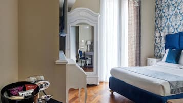 Un dormitorio con cama, tocador con espejo, candelabro y televisor sobre un pedestal.