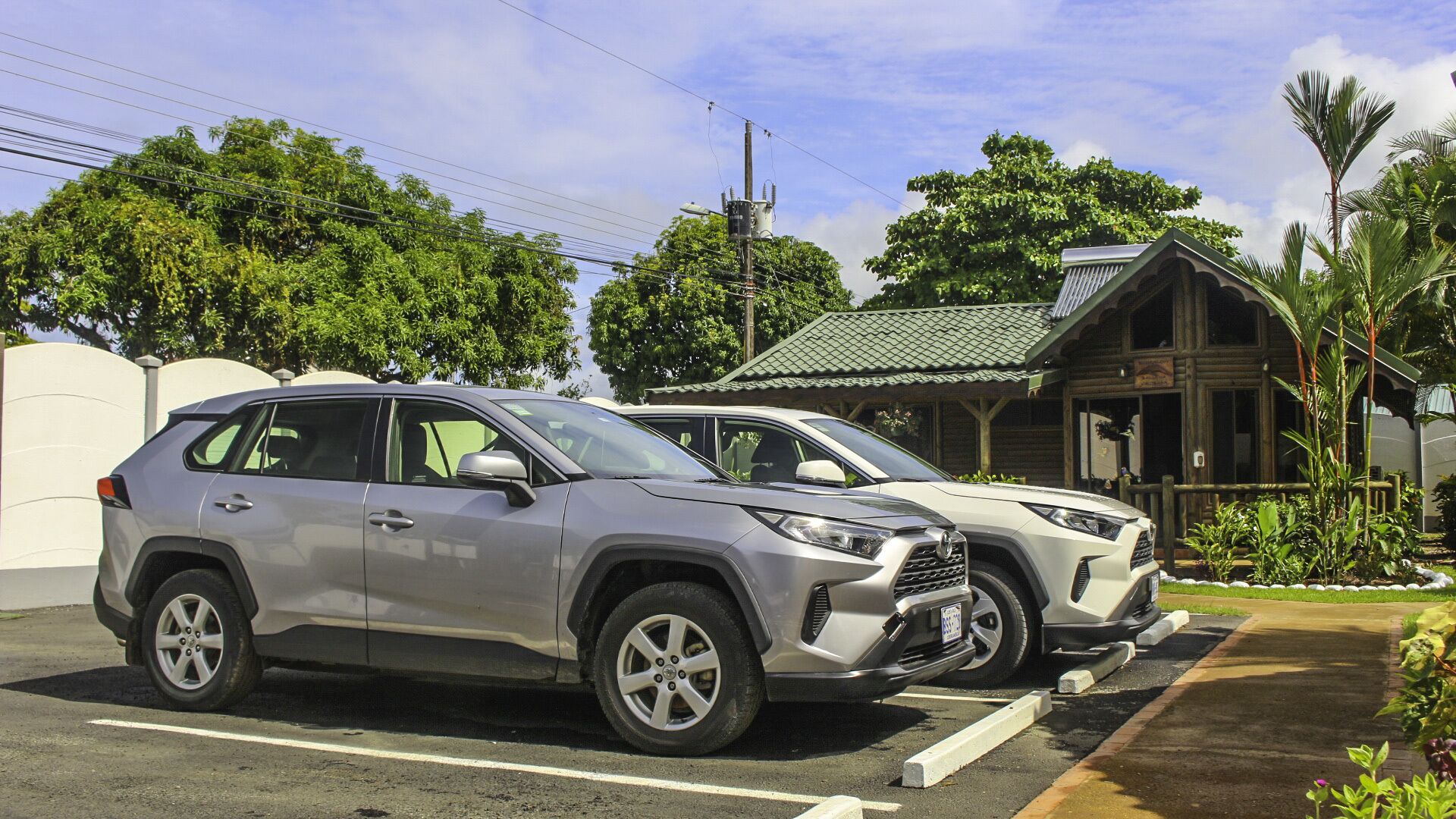 Two parked SUVs in a parking lot with a building in the background.