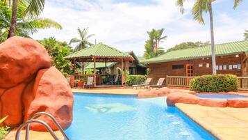 Relax by the serene pool surrounded by natural rock formations and lush greenery.
