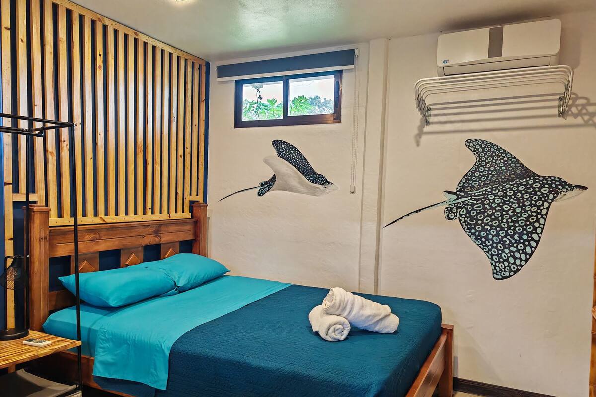 A room with a bed, a window, and a wall with a wooden slat design.