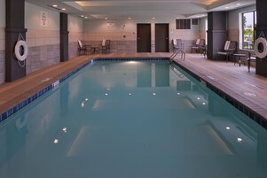 Una piscina techada, sillones reclinables de piscina