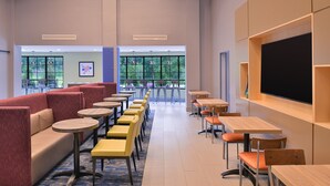 A modern classroom with rows of tables and chairs, a large blackboard, and large windows with a view of greenery. - Holiday Inn Express & Suites Bryant - Benton Area by IHG (Benton)