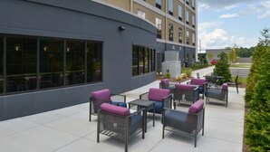 An outdoor patio area with seating and a building facade. - Holiday Inn Express & Suites Bryant - Benton Area by IHG (Benton)