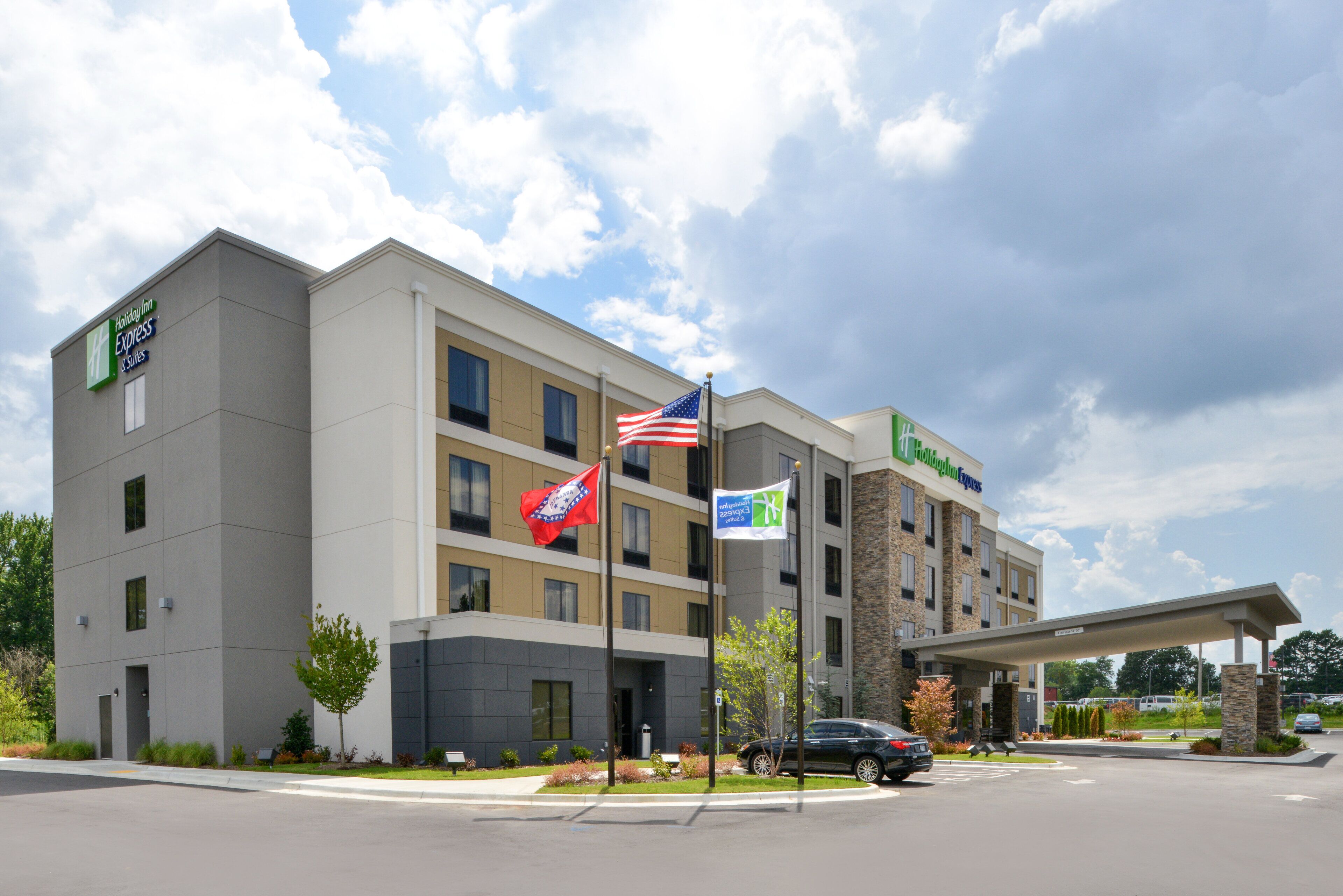 A hotel with a modern design, multiple floors, and a covered parking area.