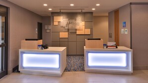 A hotel reception area with two reception desks, a blue-lit ceiling, and a patterned floor. - Holiday Inn Express & Suites Bryant - Benton Area by IHG (Benton)