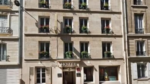 A multi-story hotel with balconies, a sign indicating it is a hotel, and a row of bicycles parked in front. - Du Bresil (Paris)