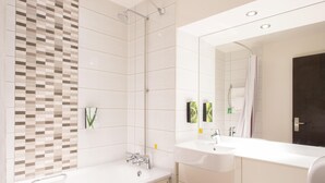 Une salle de bain moderne avec une douche, deux lavabos et un grand miroir.