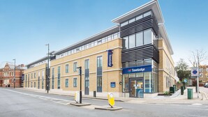 Een Travelodge hotel met een modern design, gelegen op een hoek van een straat.