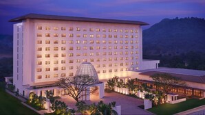 Un hotel grande y moderno con fachada simétrica, múltiples ventanales y una estructura cúpula central.