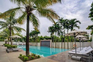 Una piscina techada, una piscina al aire libre, sombrillas