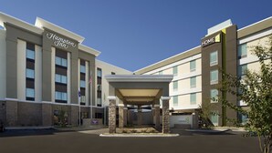 A Hampton Inn hotel with a covered entrance and a clear blue sky. - Home2 Suites by Hilton Hattiesburg (Hattiesburg)