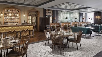 Ein Restaurant mit Barbereich, Holzsesseln und einem gemusterten Boden.