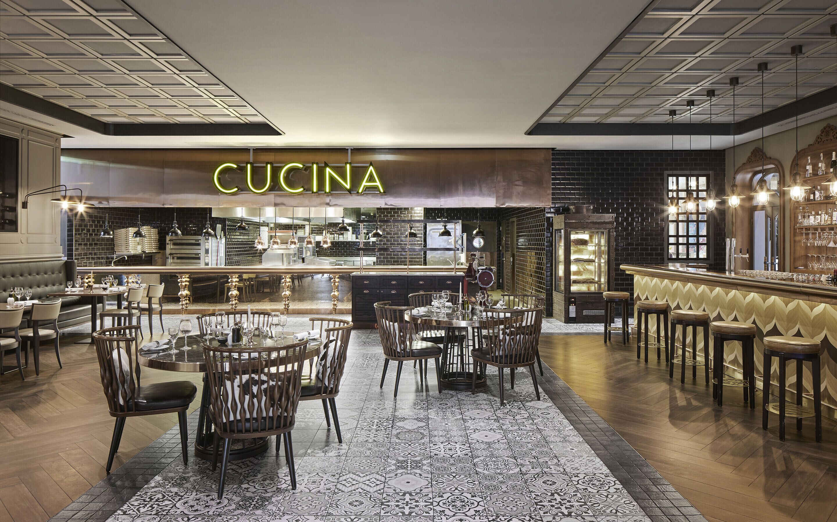 A restaurant interior with a bar area, dining tables, and chairs.