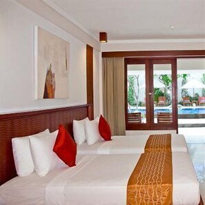 A hotel room with a bed, a painting on the wall, and a view of a pool.