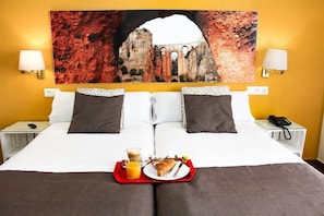 A hotel room with a bed, a breakfast tray, and a painting of a historical building on the wall. - San Francisco (Ronda)