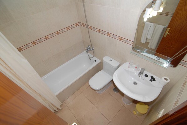 A bathroom with a bathtub, toilet, and sink.
