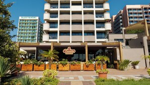 A multi-story hotel with a central entrance, balconies on each floor, and a clear sky. - Hotel Sentido Bellevue Beach Sunny Beach (Nessebar)