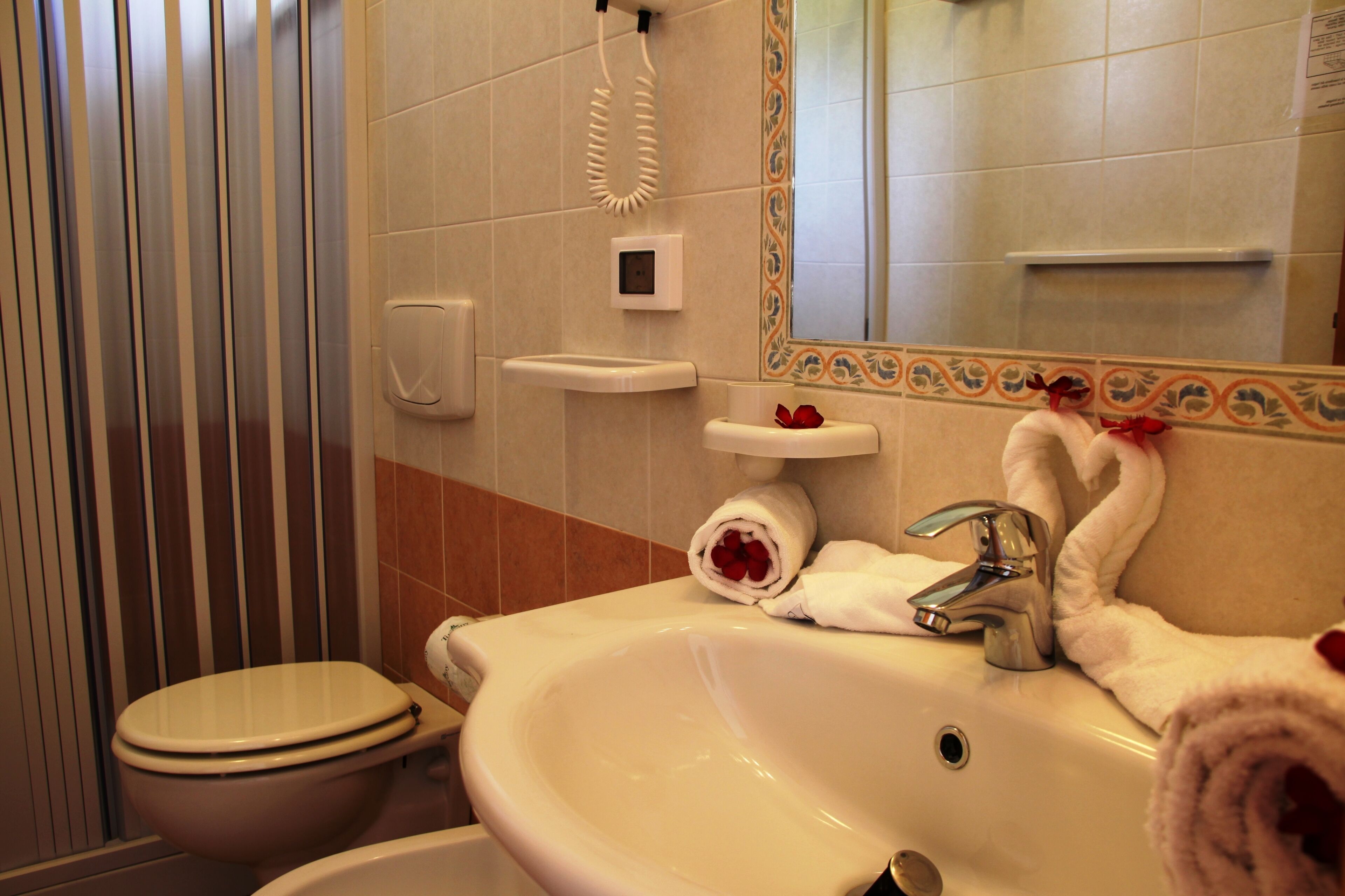 Une salle de bain avec des toilettes, un lavabo et une douche.