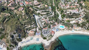 Una piscina al aire libre de temporada, sombrillas, tumbonas