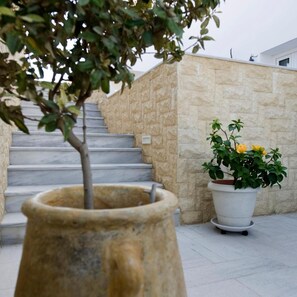 Un muro de piedra con una planta en maceta y una escalera.