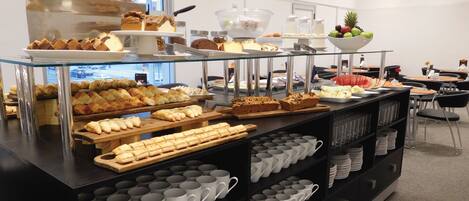 A buffet area with various food items and a coffee station.