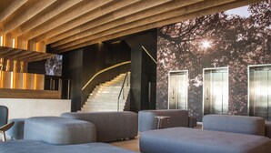 A modern interior with a staircase, seating area, and elevators. - Dazzler by Wyndham Asuncion (Asunción)