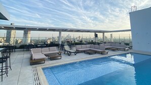 A rooftop pool area with lounge chairs and a city view. - Dazzler by Wyndham Asuncion (Asunción)