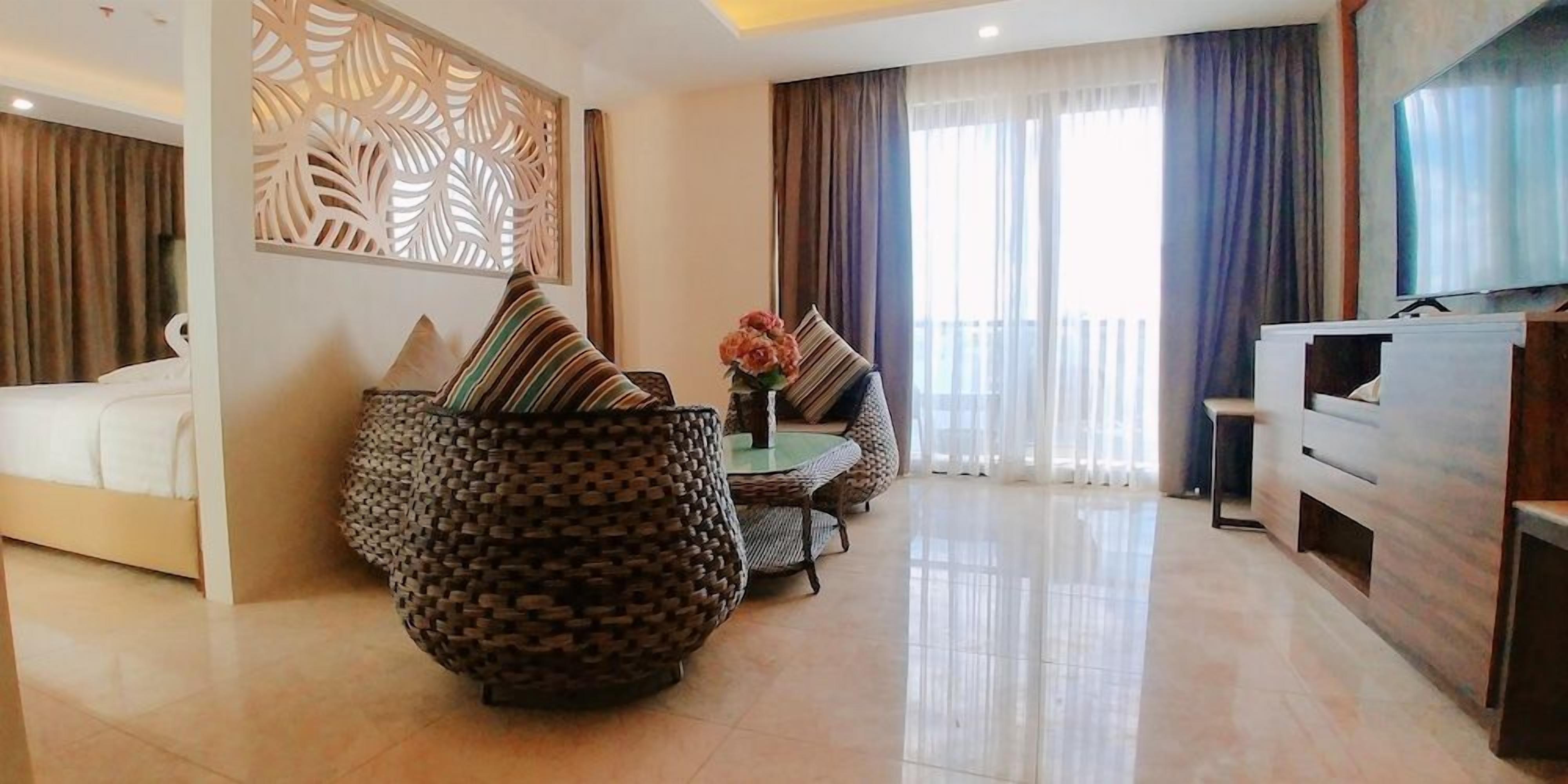 Una sala de estar moderna con un conjunto de sofás, un televisor y un panel decorativo en la pared.