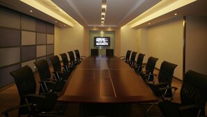 A conference room with a long table, chairs, a television screen, and recessed lighting. - Dazhong Airport South (Shanghai)
