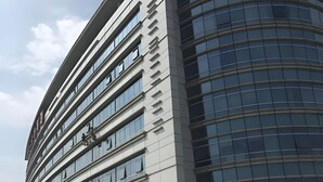 A modern building with multiple floors, large windows, and a curved facade. - Dazhong Airport South (Shanghai)