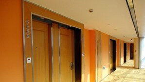 A hotel corridor with wooden doors numbered 6839, a patterned carpet, and a ceiling with recessed lighting. - Dazhong Airport South (Shanghai)