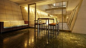 A modern interior with a reception desk, seating area, and a staircase. - Hotel Villa Fontaine Tokyo - Ueno Okachimachi (Tokyo)