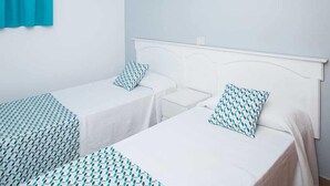 A room with two single beds, each with a patterned bedspread and matching pillows. - Montesol Atsol (Mogan)