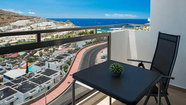 A balcony with a view of a coastal town and the sea. - Montesol Atsol (Mogan)