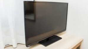 Ein Flachbildfernseher auf einem Holzboden in einem Zimmer.