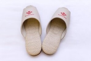 A pair of slippers with a herringbone pattern on the sole and a logo on the top.