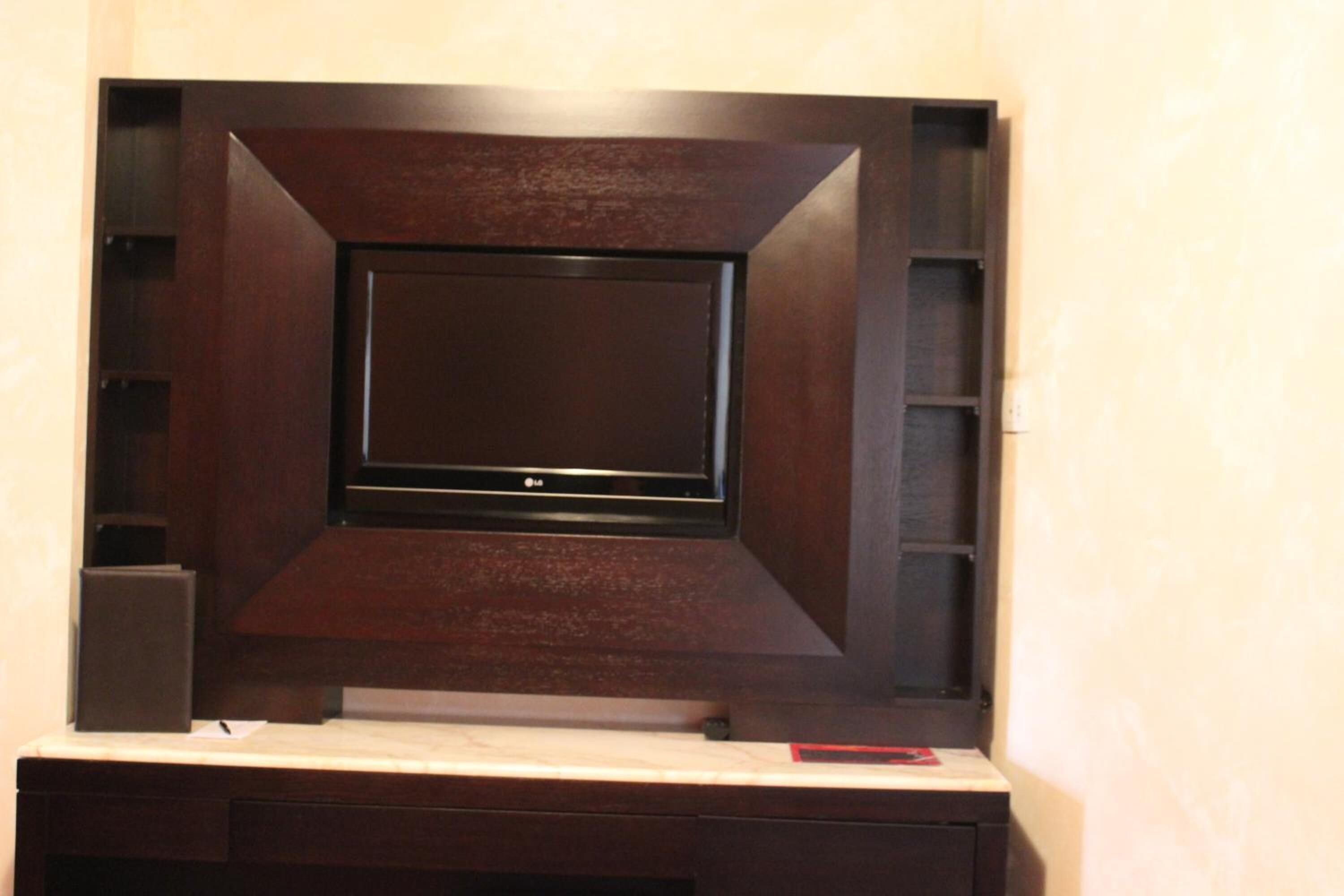 Un mueble de madera oscura con centro de entretenimiento y un televisor de pantalla plana.