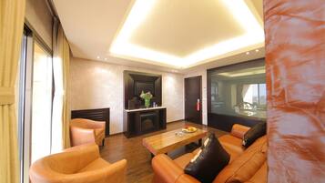 A modern living room with leather sofas, a wooden coffee table, and a fireplace.