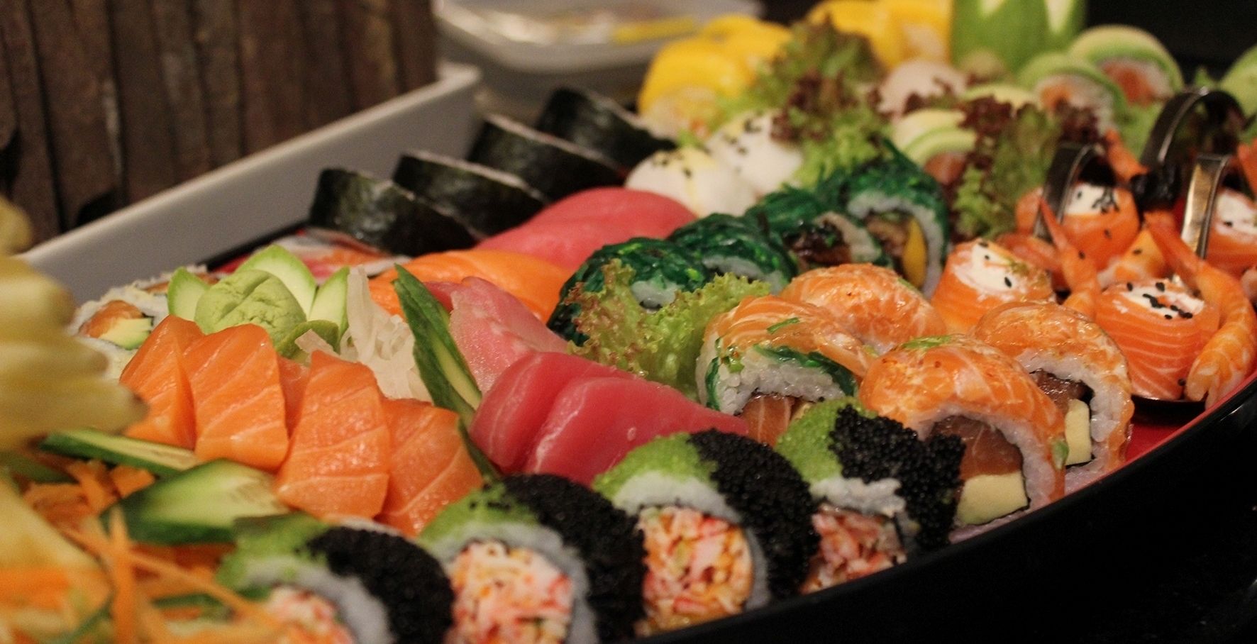 A variety of sushi dishes including nigiri and rolls, arranged on a tray.