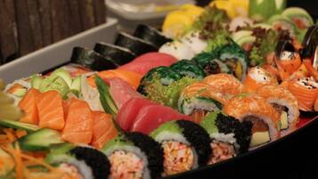 A variety of sushi dishes including nigiri and rolls, arranged on a tray.