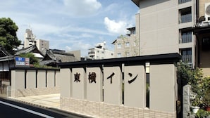 Un bâtiment de style architectural japonais traditionnel, caractérisé par un toit recouvert de tuiles et une enseigne avec des caractères japonais.