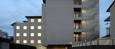 Un edificio moderno de varios pisos con fachada plana, ventanas grandes y balcones.