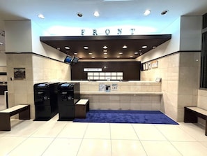 A reception area with a 'FRONT' sign, a digital kiosk, a clock, and a blue carpet. - Toyoko Inn Kyoto Gojo-omiya (Kyoto)
